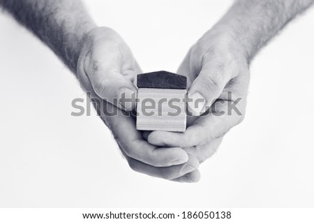Man hands holds toy house isolated on white background - copy space.Concept photo of real estate business, home Insurance, house rental,buying, renting, mortgage, finance,service and repair costs (BW)