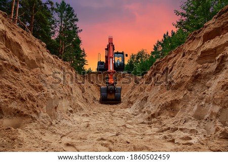 Excavator dig trench at forest area on amazing sunset background. Backgoe on earthwork for laying crude oil and natural gas pipeline or water main pipes. Construction the sewage and drainage
 Royalty-Free Stock Photo #1860502459