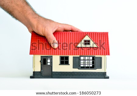 Man hand holds toy house isolated on white background - copy space.Concept photo of real estate business, home  Insurance, house rental,buying, renting, mortgage, finance,service and repair costs