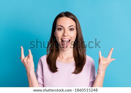 Closeup photo of attractive crazy funky lady open mouth protruding tongue out mouth listen hard rock song making fingers horns wear casual purple sweatshirt isolated blue color background