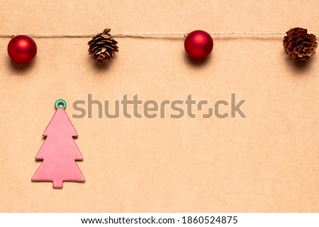 Christmas greetings card with a garland of balls and pineapples and red cardboard tree. Space for copying. Advertising banner