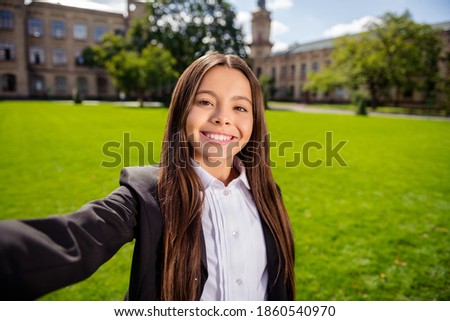 Photo of cheerful schoolgirl take selfie toothy beaming smile wear black uniform white shirt urban city outside