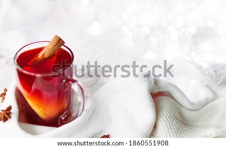 Cup of hot winter drink with knitted sweater on the table, closeup