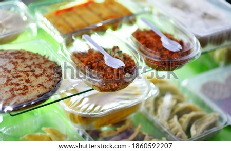 A variety of prepackaged food products in plastic boxes.