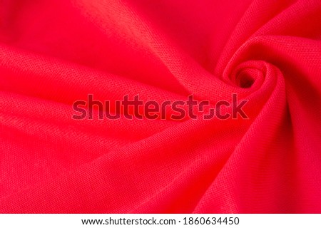 Red cloth. abstract background of luxury fabric or liquid silk texture of waves or wavy folds. background or elegant wallpaper design. Cotton texture, natural fabric and dye, bright red color.