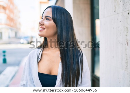 Young hispanic girl smiling happy walking at the city.