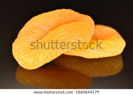 Bright golden organic dried apricots, close-up, isolated on black.