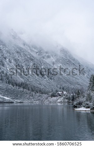 First snow Morning at Eye of the Sea or Morskie Oko Lake in tatras national park poland Snow-covered winter mountain lake in a winter atmosphere and hut. Beautiful background photo