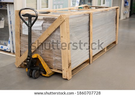 OSB sheets are stacked in a hardware store. The building material is wood. Lie in the cart