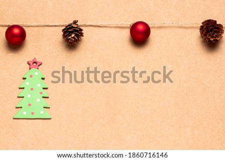 Christmas greetings card with a garland of balls and pineapples and green cardboard tree. Space for copying. Advertising banner