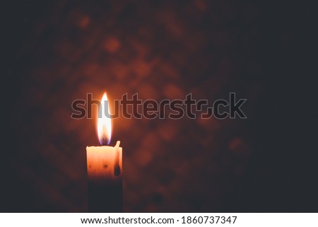Candlelight in the dark, a symbol of peace or sadness. Cinematic look photo.