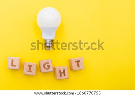 Word Light and light bulb on yellow background, concept picture, layout with space for text, top view