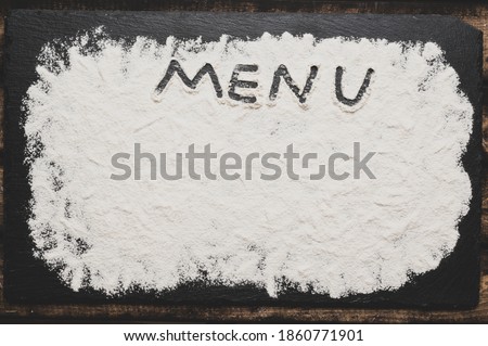 Menu sign with flour Artwork With Food And Handprints, Fun background with human handpints in scattered flour on the dark background. Copy space