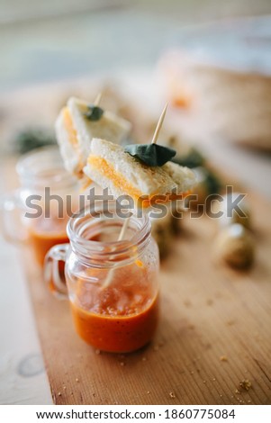 Bite sized grilled cheese in glass of tomato soup appetizer  Royalty-Free Stock Photo #1860775084