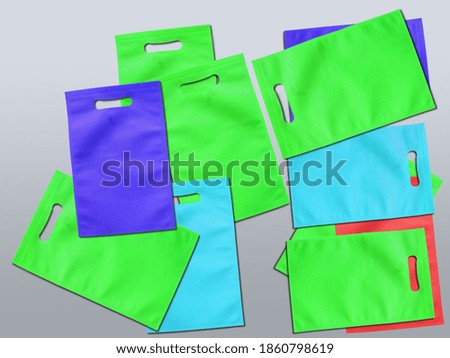 Assorted Color Bags D-Cut Type Non Woven Fabric on Background. Die Cut Gift Bags, Reduce, Reuse, Recycle. Use Me I am not Plastic. ECO Friendly Environment Concoct.  