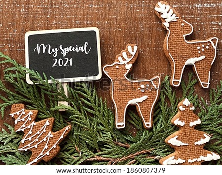 Hello 2021 chalkboard with homemade Christmas cookies on brown wooden background top view 