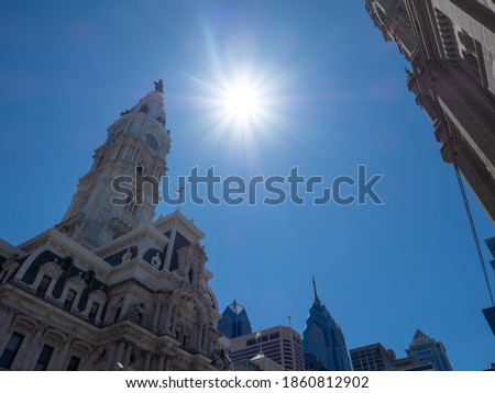 A bright shining sun near the city hall and the surrounding skyline of Philadelphia.
