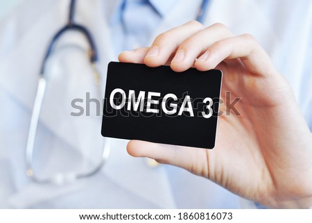 Doctor holding a black paper card with text Omega 3, medical concept. Omega 3 card in hands of medical doctor