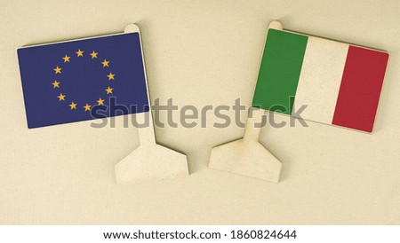 Flags of the European Union and Italy made of recycled paper on the cardboard desk, flat layout