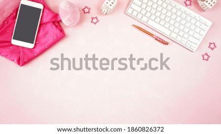Christmas holiday feminine pink theme desktop workspace with lady santa hat and accessories on stylish pink textured background. Top view blog hero header creative composition flat lay. Copy space.
