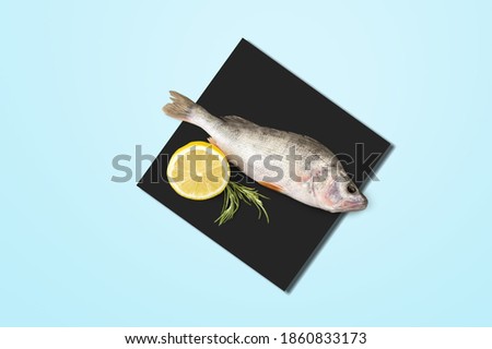 Fresh raw fish, placed on a black and pastel blue background