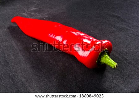 Fresh organic red chili peppers on a black background, close-up