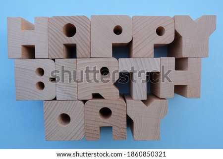 Happy Birthday text composed with wooden letters over blue background