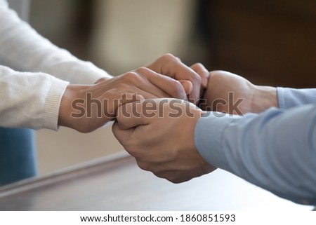 Together we will manage it. Close up of young loving couple diverse friends or relatives holding hands together with affection care. Supporting comforting in difficult life period, having sincere talk