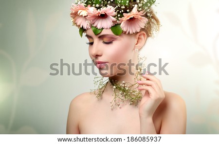beautiful girl wearing wreath of flowers on light background