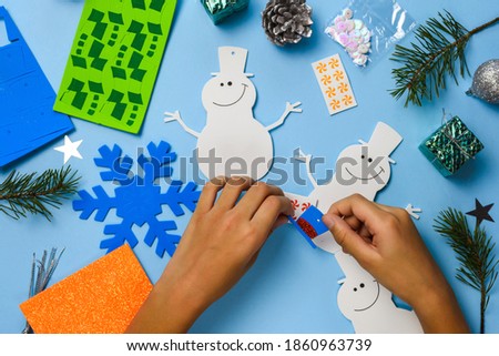 Christmas tree hanging ornaments. Snowman parts on blue wooden background. Christmas crafts ideas. Top view.