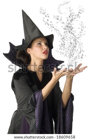 pretty witch with black dress and hat doing a magic spell