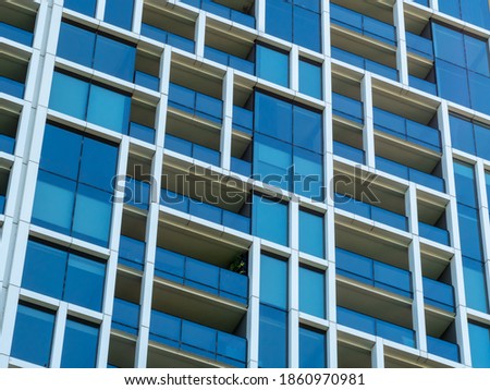 Modern windows and balconies close up in a multi-dwelling building. Apartments in a strata living scheme of common property. Royalty-Free Stock Photo #1860970981
