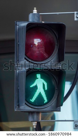 Green pedestrian light in an urban context. Person or male walking figure.