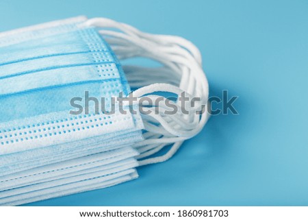 Medical protective masks on a blue background are stacked.