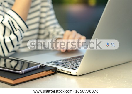 Search Engine Optimization - SEO concept. Closeup of a female hands using laptop computer with a smartphone on the table. Machine learning, AI Artificial intelligence, Smart search, Keyword research.