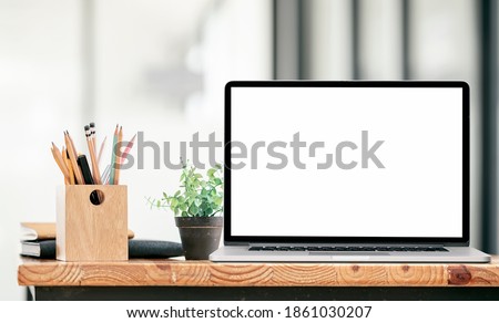 Mockup blank screen laptop computer with stationary on wooden table, blank screen for graphic design.