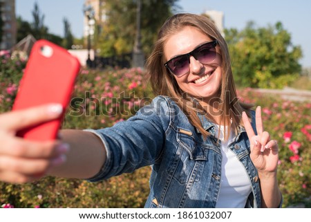 Pretty blonde girl makes selfie on smartphone