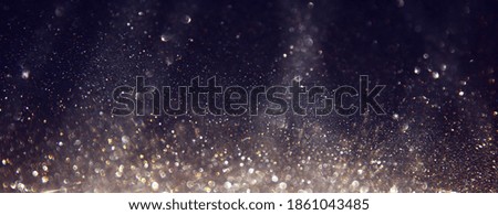background of abstract glitter lights. silver, gold and black. de focused