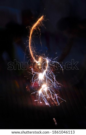 Family celebrating the festival of Diwali with a sparkler, India (portrait)