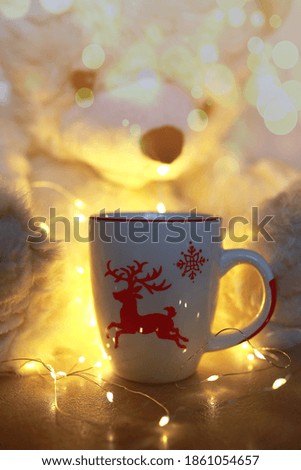 A cup of hot tea for Christmas and New Year. Background in the form of a cup and lanterns.