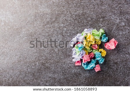 Top view flat lay of crumpled paper stick note ball on office desk concrete background with copy space for text