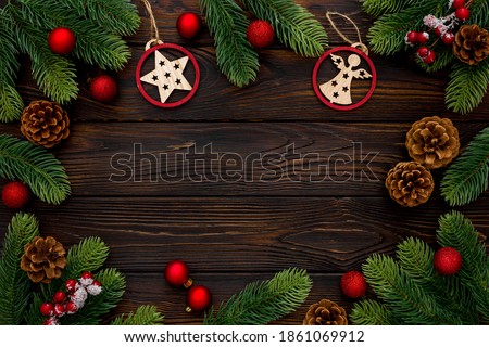 Spruce branch, cones and vintage toys decoration on christmas or new year on dark wooden background
