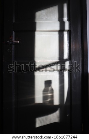 A dark picture of door with shadows on it.