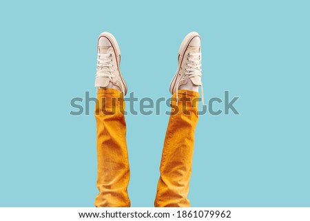 Cropped shot of white footwear, gumshoes on blue studio background