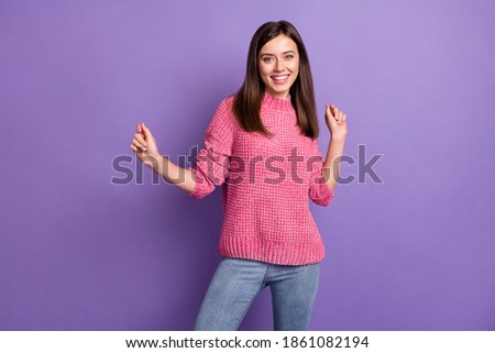Photo portrait of dancing pretty young woman happy wearing pink sweater isolated on bright violet color background