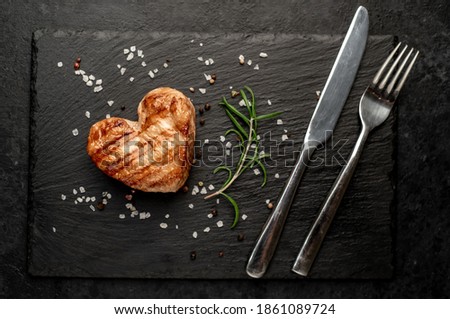 
Heart shaped grilled pork steak for valentine's day on stone background