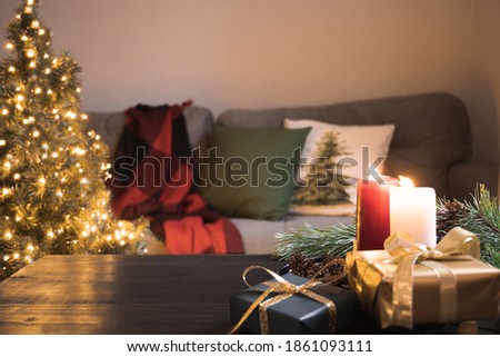 Cozy home interior in living room with Christmas tree, sofa, wooden tabletop and candles. Xmas holiday at home.
