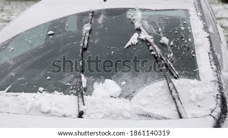 Wiper blades clean the car's windshield from snow, winter snowstorm icing vehicle after snowfall, safe winter driving, preparing for the trip Royalty-Free Stock Photo #1861140319