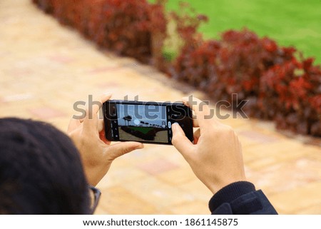 A man hands holding hand phone for taking a picture