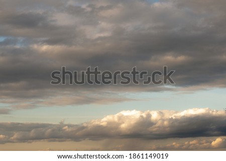 Against the background of the blue sky, gray, large storm clouds.